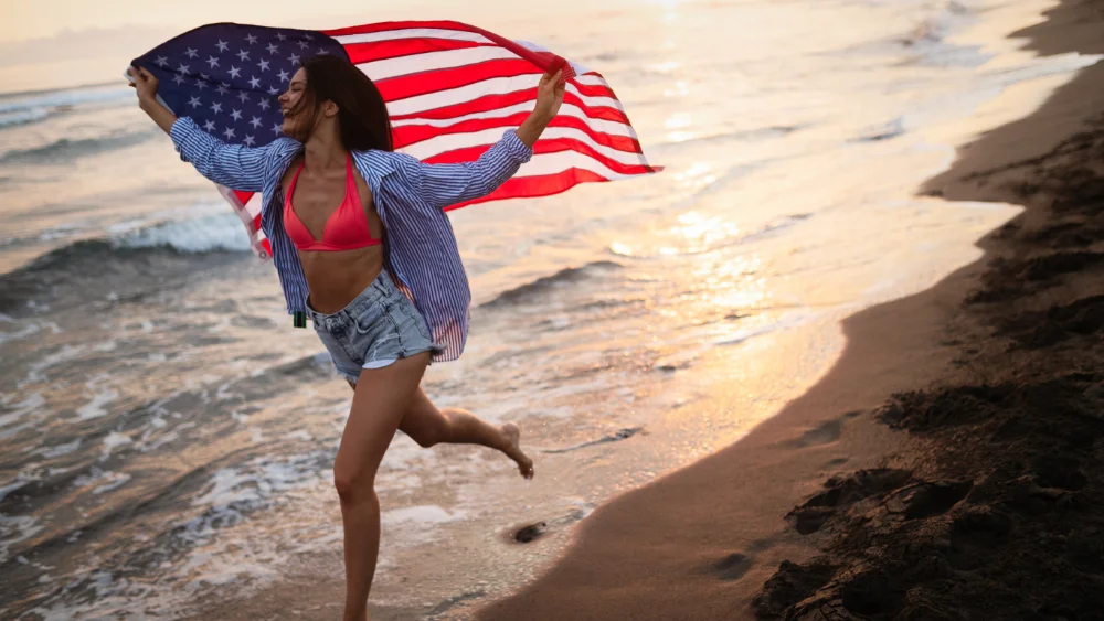 Happy woman running on beach while enjoying summer in USA